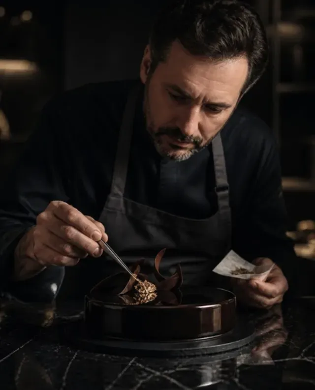 Matei, Pâtissier, beim Vergolden einer Schokoladentorte